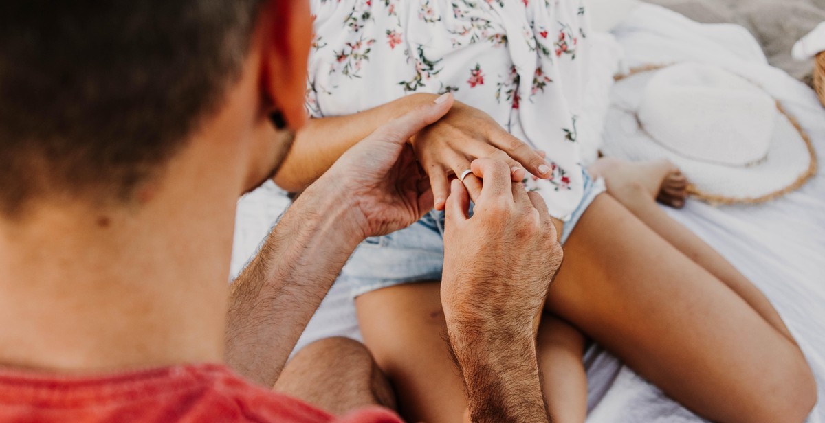 couple holding hands with engagement ring